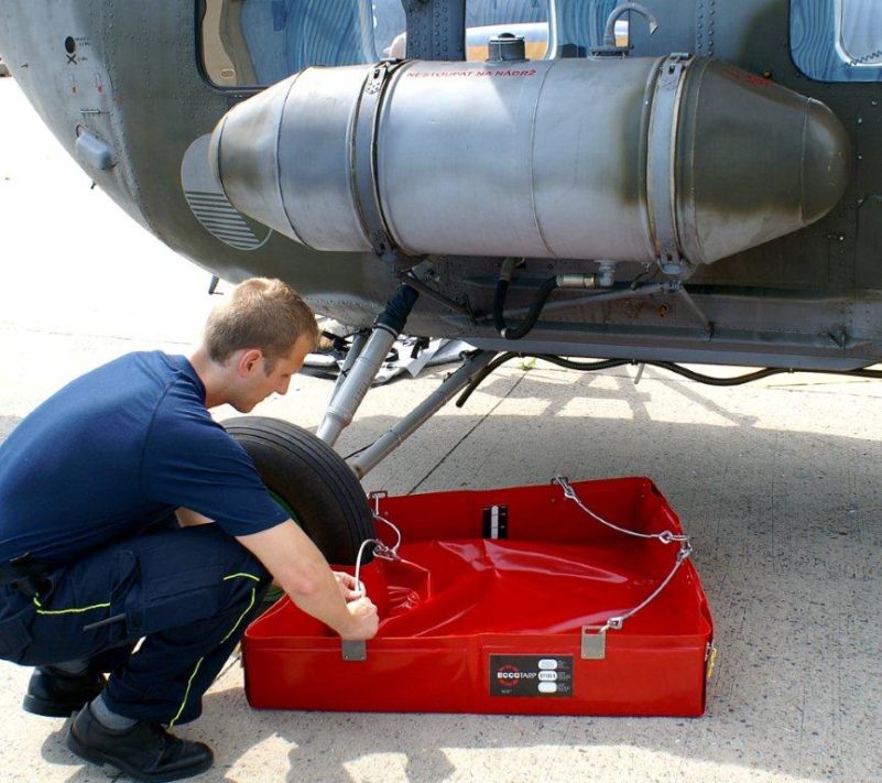 Mechanic performs maintenance on helicopter landing gear.