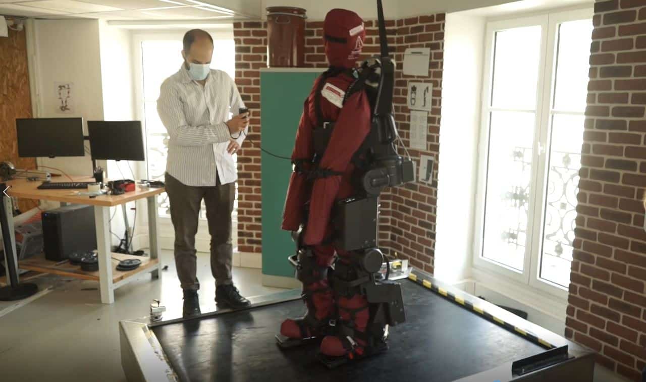 Engineer tests advanced robotic exoskeleton in laboratory setting.