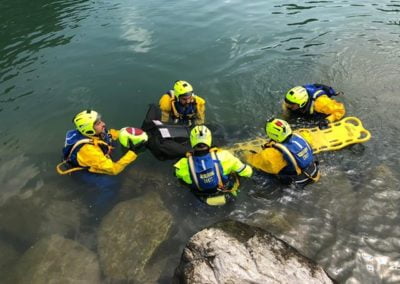 Rescue team conducting water rescue training with equipment.