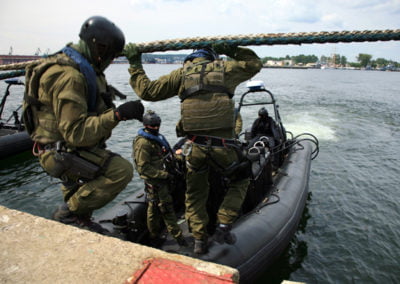 Military personnel boarding a boat for a mission.