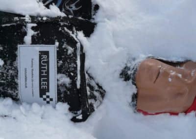 Training mannequin in snow for rescue practice.