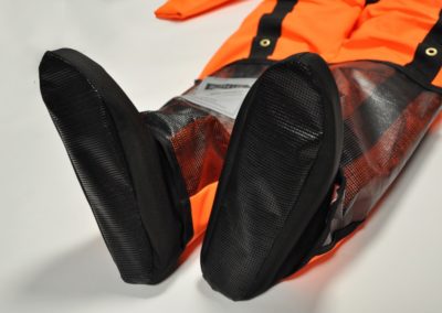 Close-up of orange waterproof trousers with reinforced knees.