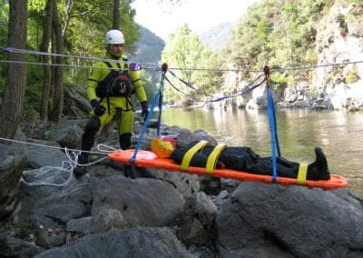River rescue training with stretcher and ropes.