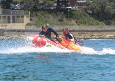 Rescue workers on jet ski in coastal waters.
