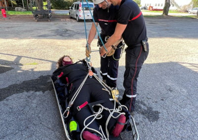 Rescue workers securing person on stretcher during training.