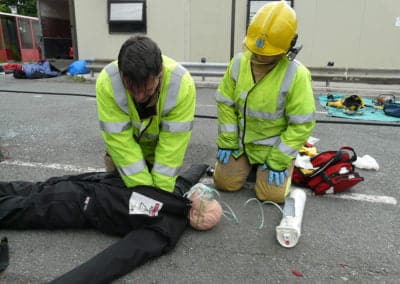 Emergency responders practising CPR on a mannequin.