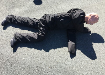 Training dummy lies on asphalt for emergency practice.