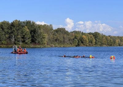 Rescue boat and swimmers training in lake.