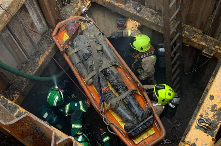 Firefighters rescuing a person from a confined space.