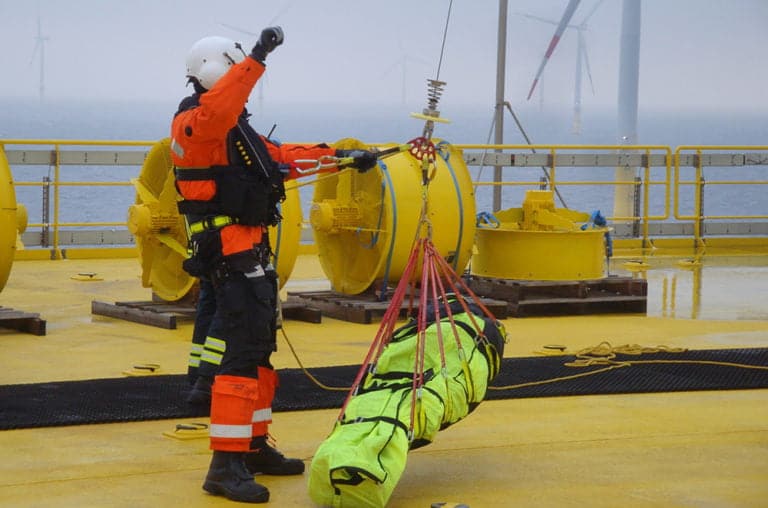 Offshore worker performing a rescue operation with training manikin.