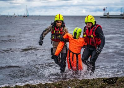 Man Overboard Training Manikin being pulled from sea by two rescuers