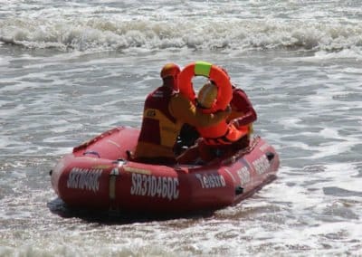 Lifeguards on a rescue boat in the ocean waves.