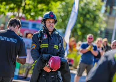 Firefighter participating in a community event with a crowd.