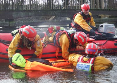 Rescue team practicing water rescue in a river.