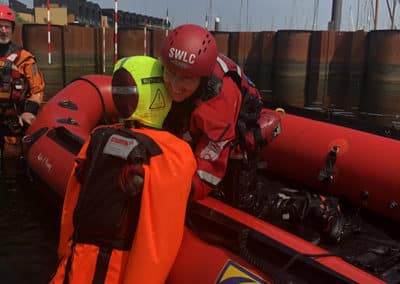 Rescue training in inflatable boat on water.