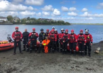 Rescue team in gear by lakeside.