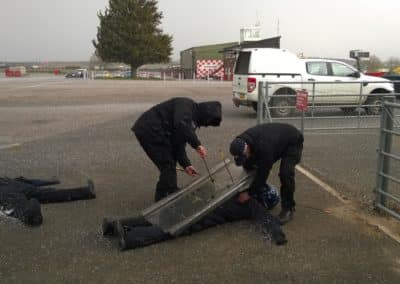 Training exercise: police officers use shields in a snowy area.