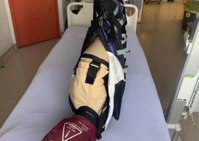 Hospital bed with patient in a medical harness.