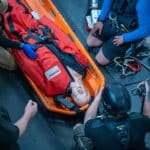 Rescue team training with a mannequin in stretcher.