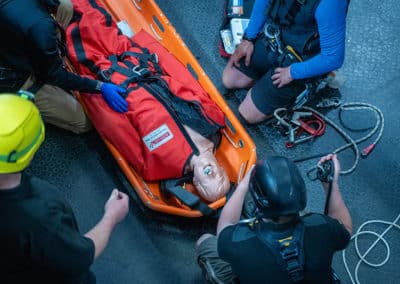 Rescue team training with a mannequin in stretcher.